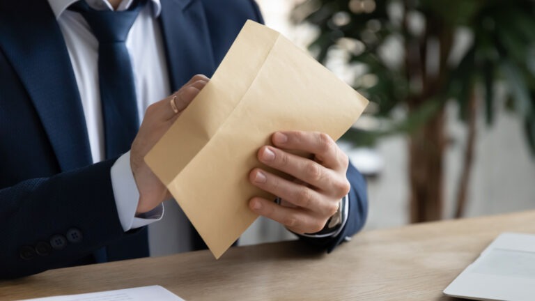 Hands of businessman opening paper envelope,